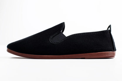 Javer Black slip-on shoe with brown sole on a white background
