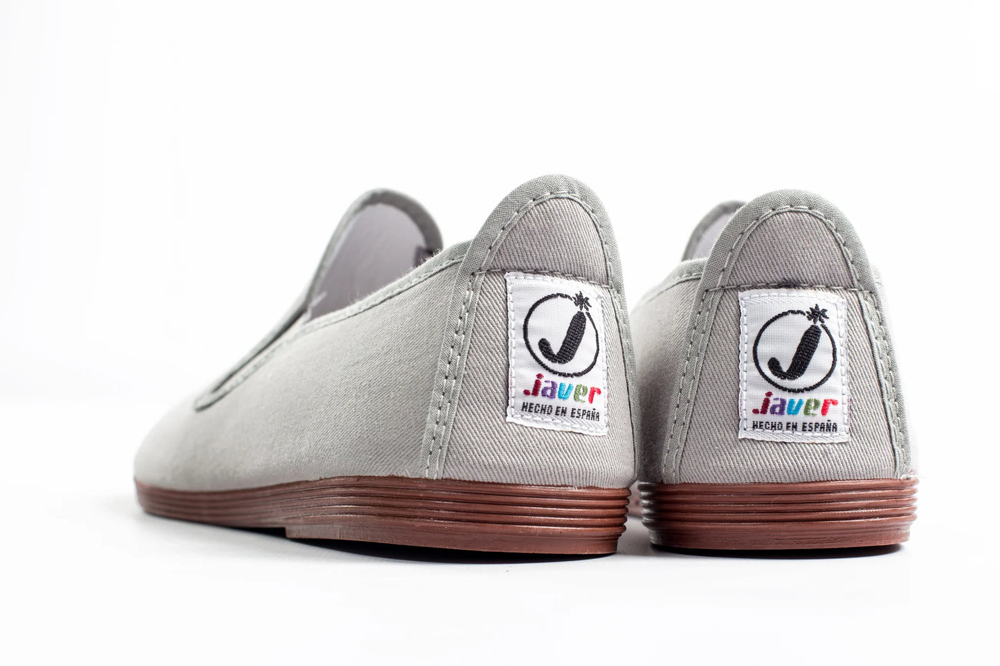 Javer Pair of gray slip-on shoes with colorful labels on a white background