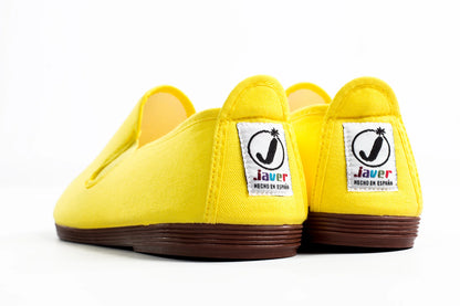 Yellow slip-on shoes with brown soles and visible brand logo on a white background