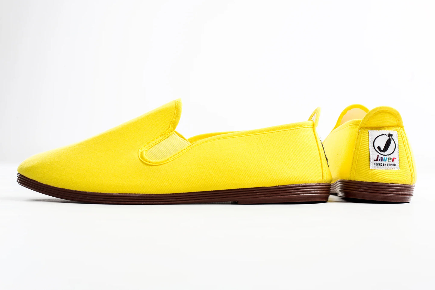 Yellow slip-on shoes with a visible brand logo on a white background