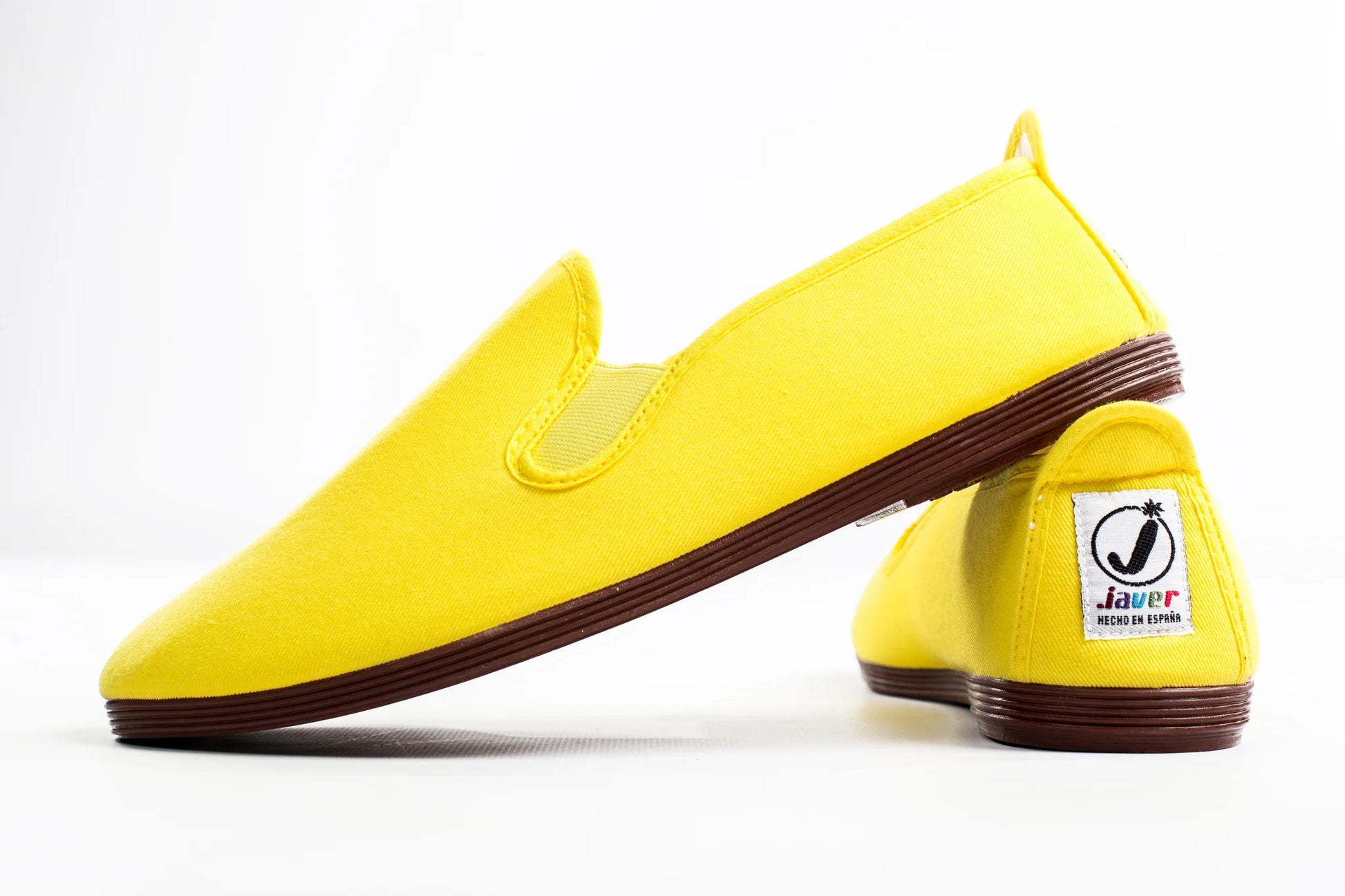 Javer Yellow loafers with brown soles on a white background